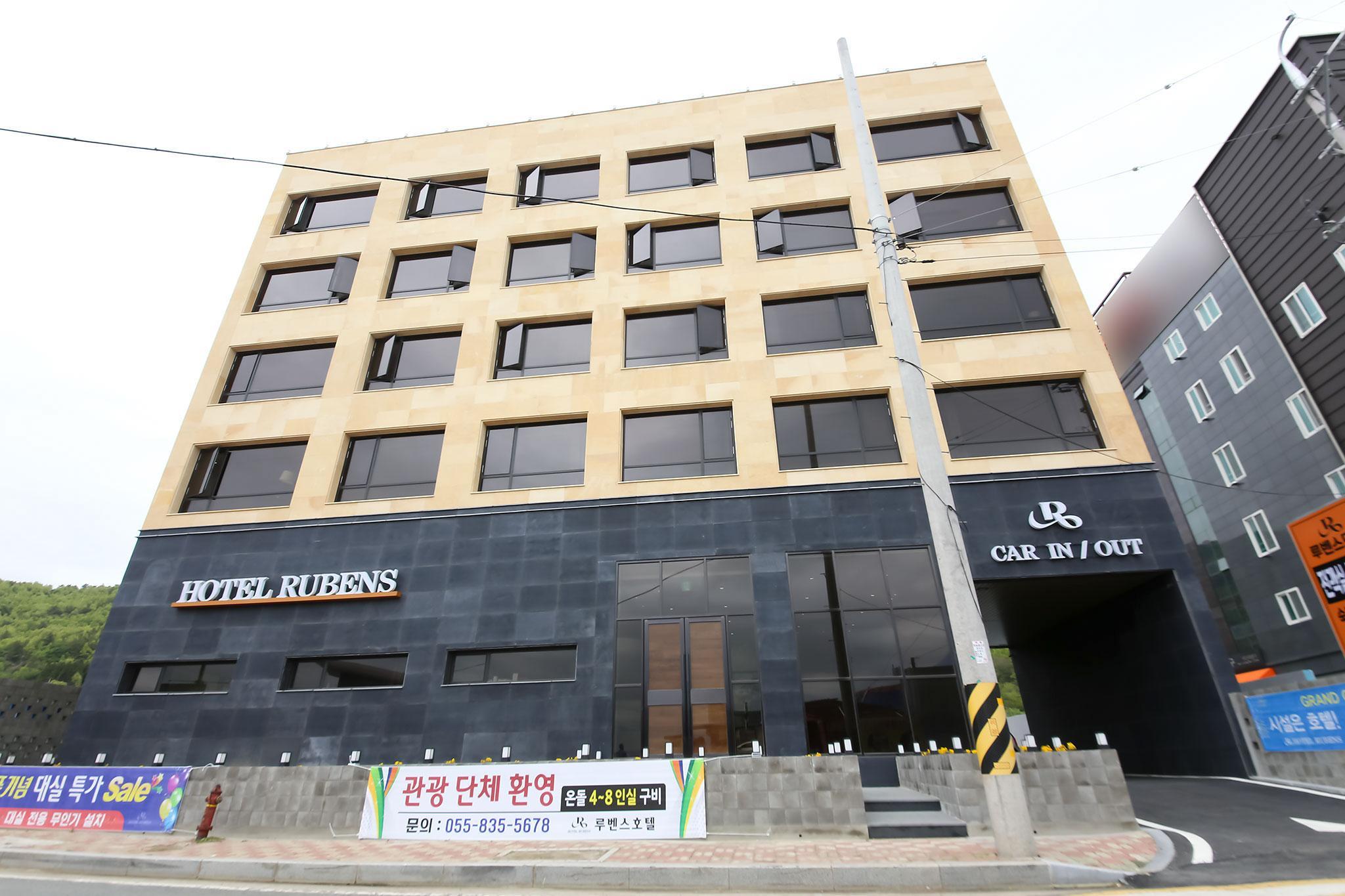 베이지색 석재와 검은 외벽으로 마감한 루벤스호텔 외관. ‘HOTEL RUBENS’ 간판 오른쪽에 차량 출입구가 보인다