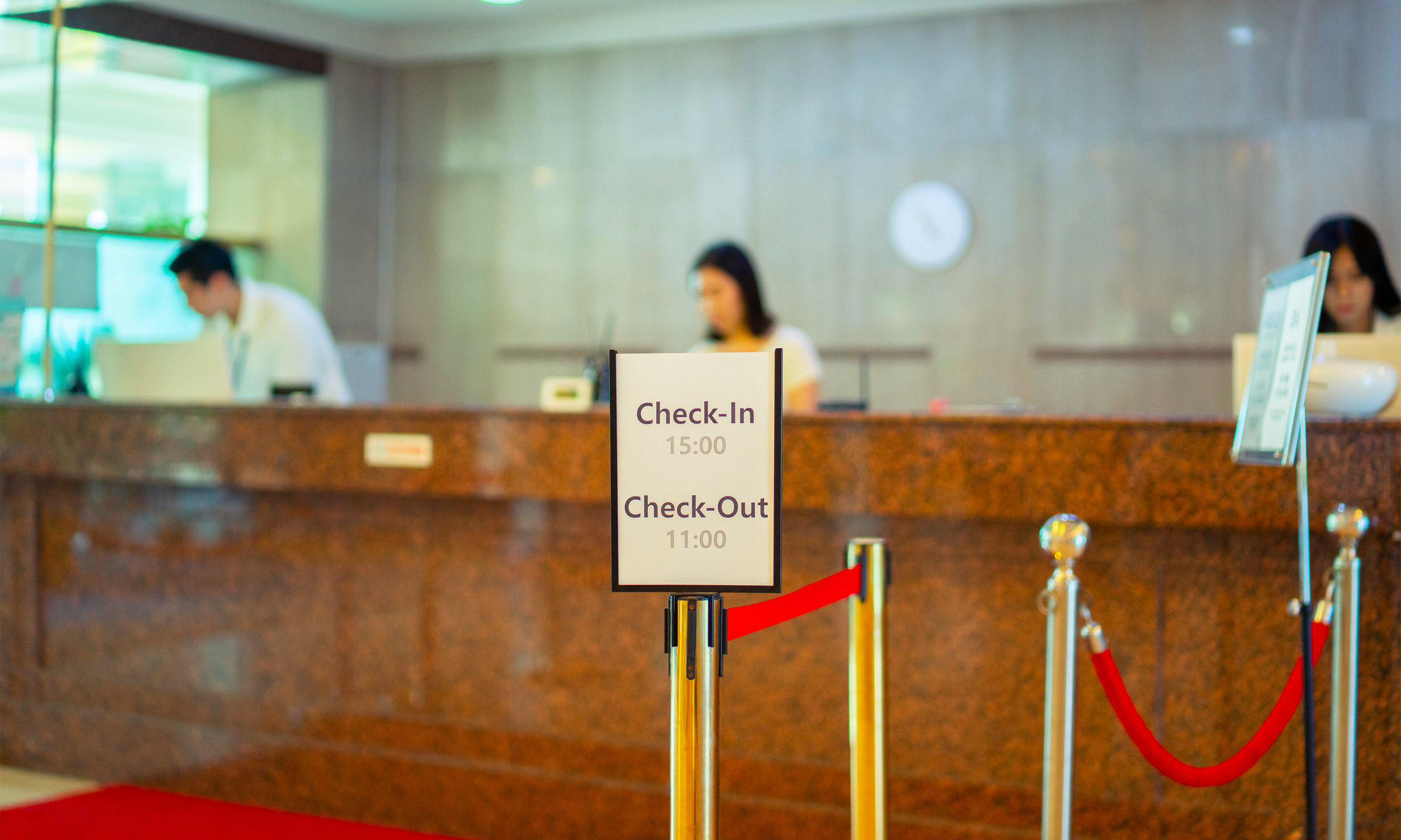 프런트 앞 ‘Check-In 15:00 / Check-Out 11:00’ 안내판